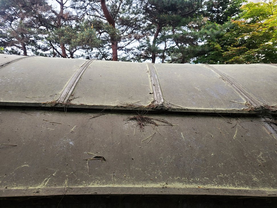 특수청소 작업 전 오염 상태 렉산 패널 연결 이음새와 틈새에 묵은 먼지 및 낙엽 잔재가 고착되어 있는 모습입니다.